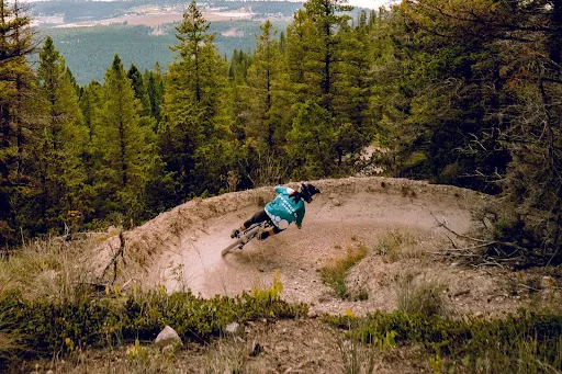A mountain biker riding a berm.