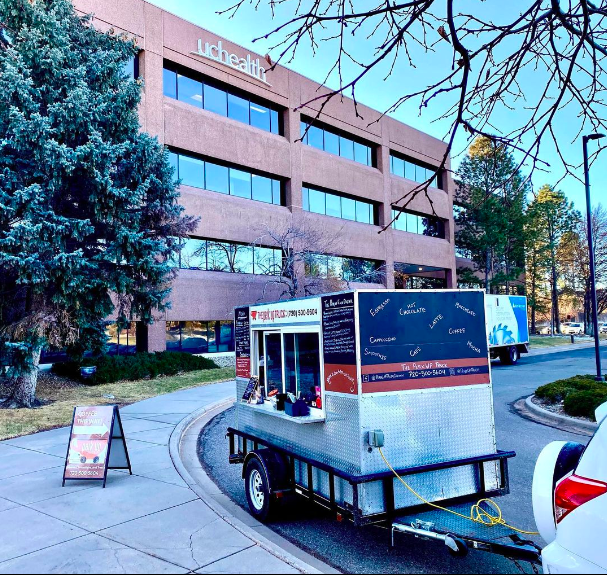 A trailer sits parked in front of a red brick building.