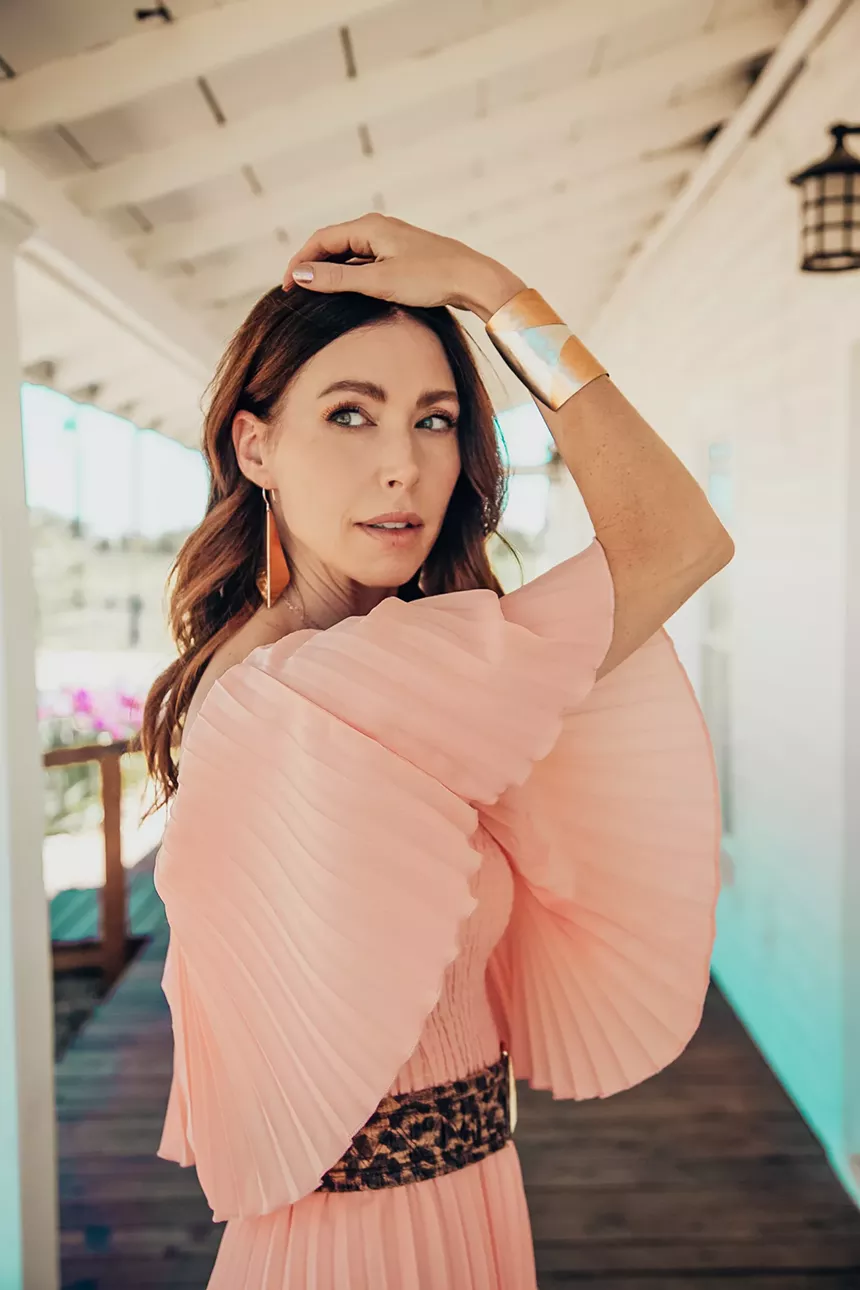 woman in pink shirt with gold arm cuff