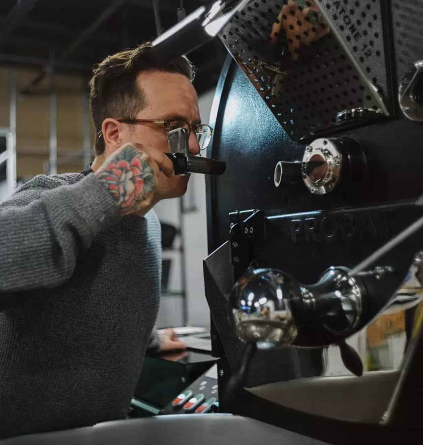 a man using a coffee roasting machine