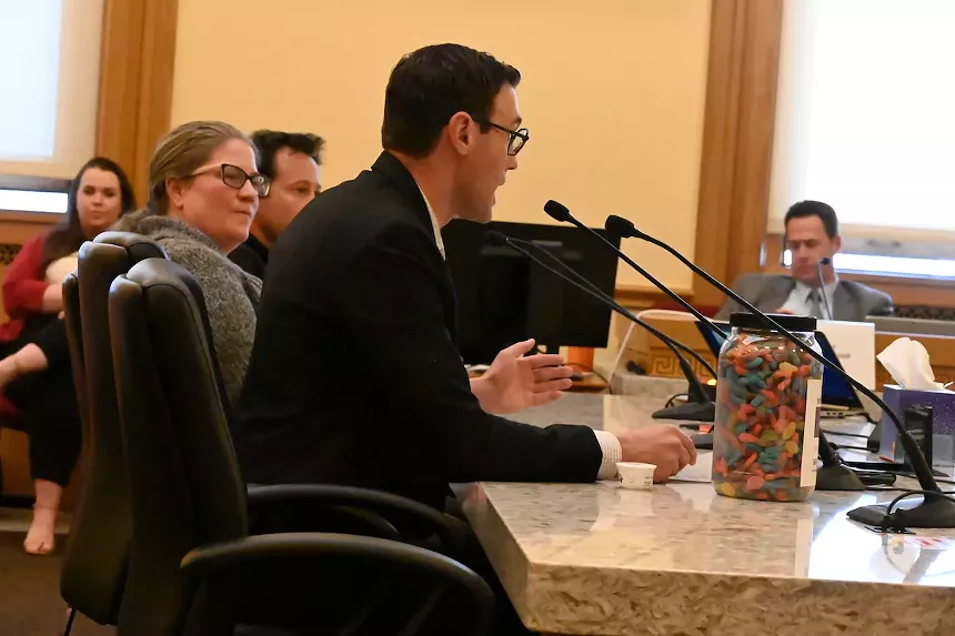 Truman Bradley testifies in front of the Colorado Senate Finance Committee on Wednesday about the need to limit THC content per package size with Senate Bill 271 and uses a large jar of regular candies to demonstrate how large some containers can be.