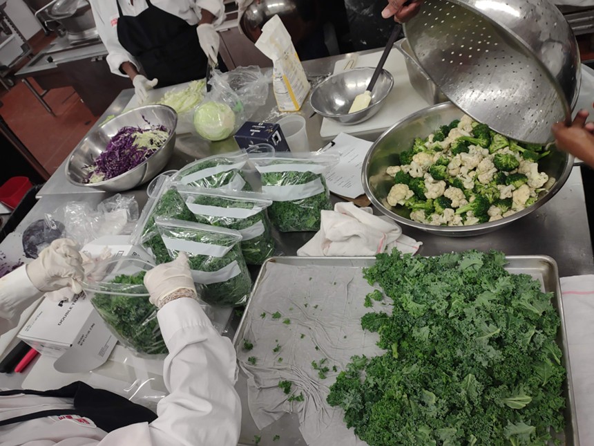 a table of vegetables being chopped and bagged