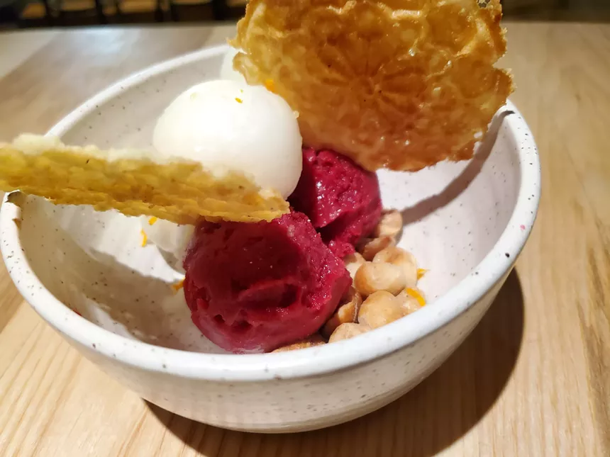 scoops of sorbet with thin, flat cookies on top