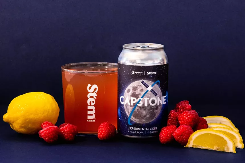Cider can and glass with raspberries and lemons