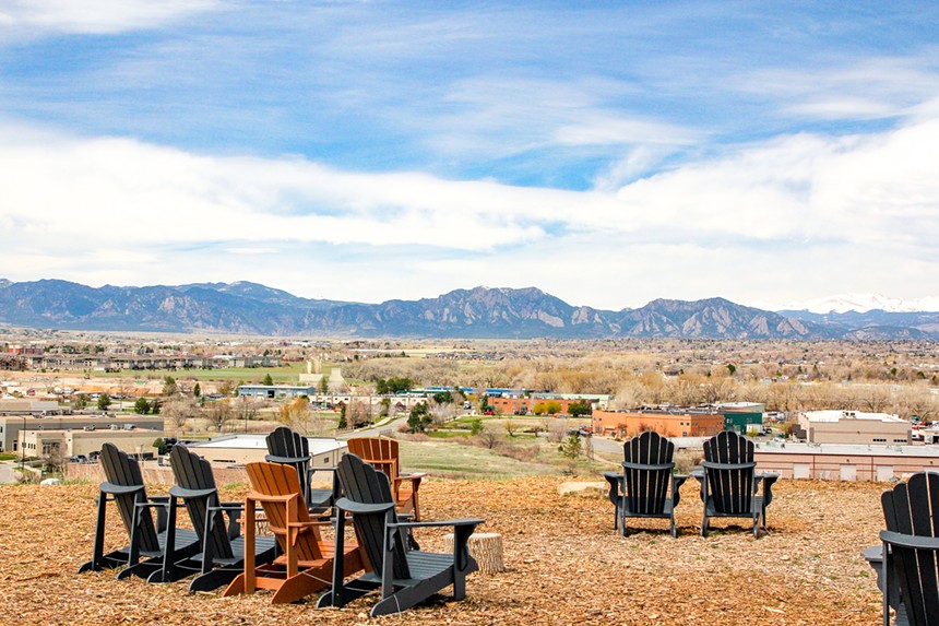 Adirondack chairs facing a view of the Rocky Mountains.