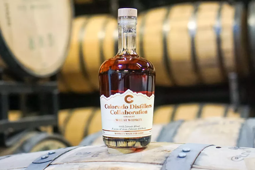 Bottle of Colorado whiskey with barrels in the background.