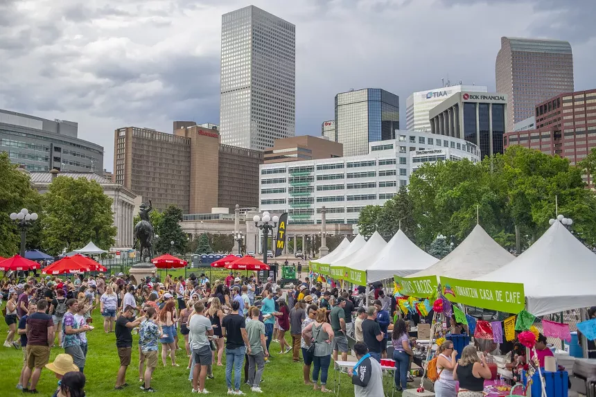 people standing in a park in front of a city skyline
