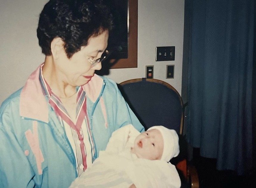 an older Japanese woman holding a baby