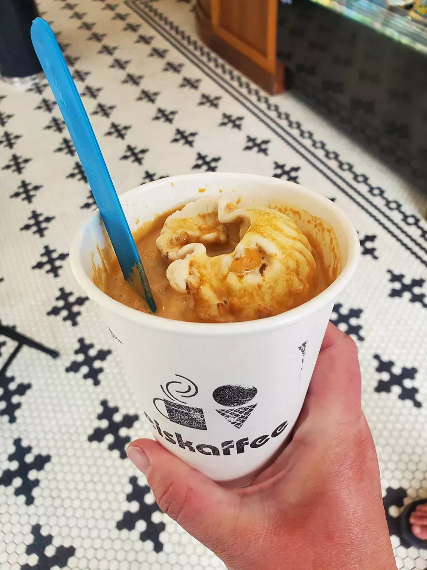 a white cup filled with ice cream and espresso