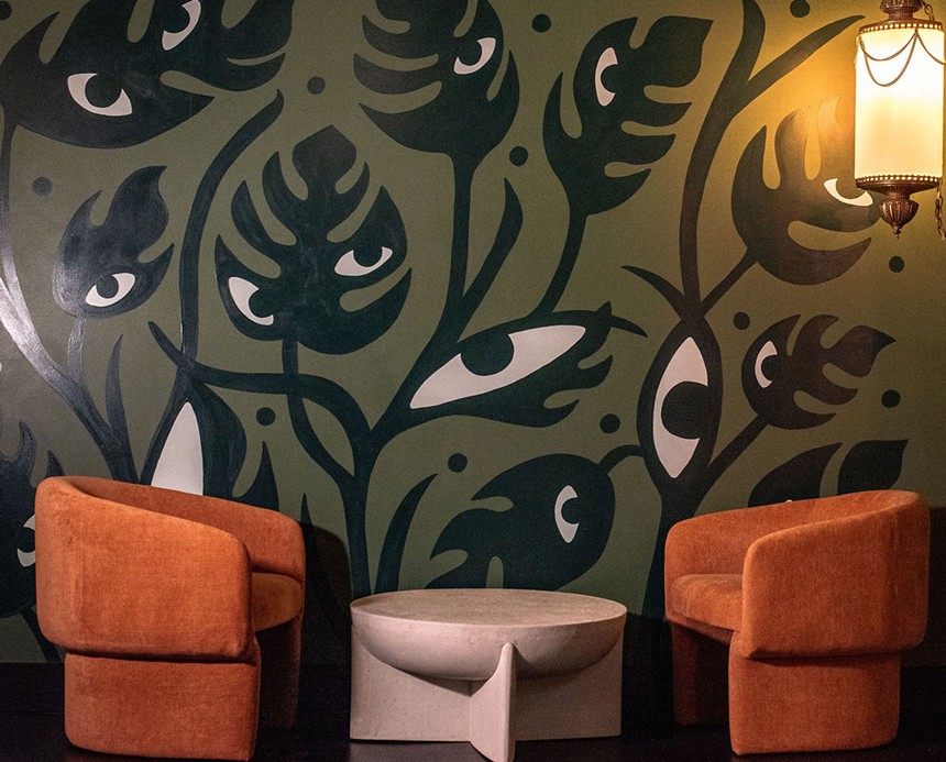 A tropical mural inside a lounge with eye-shaped motifs