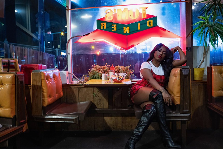 woman poses at a diner booth