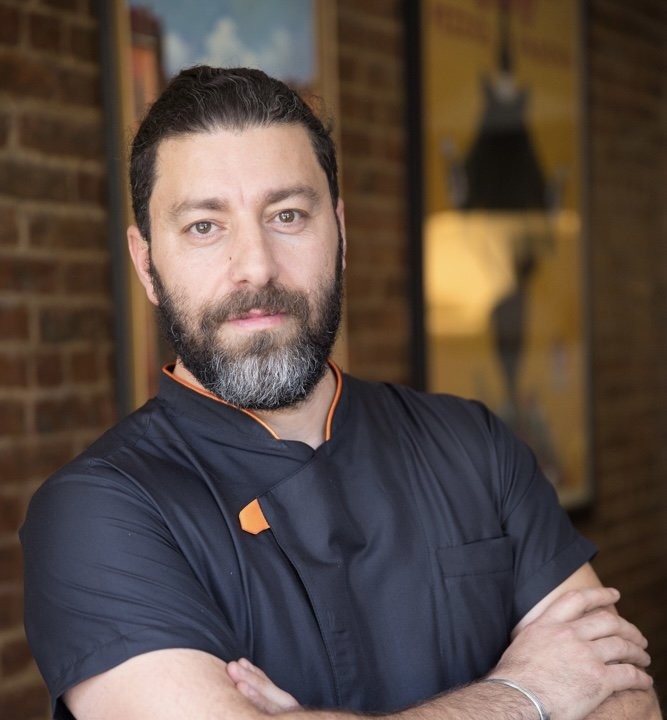 a man in a chef coat with a beard