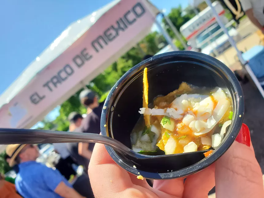 a small cup with tortilla chips and green chile