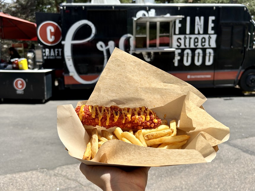 A corn dog platter backdropped by a food truck