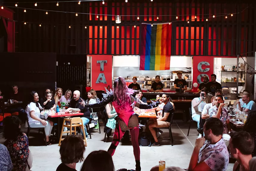 drag queen dancing in a restaurant among tables and diners