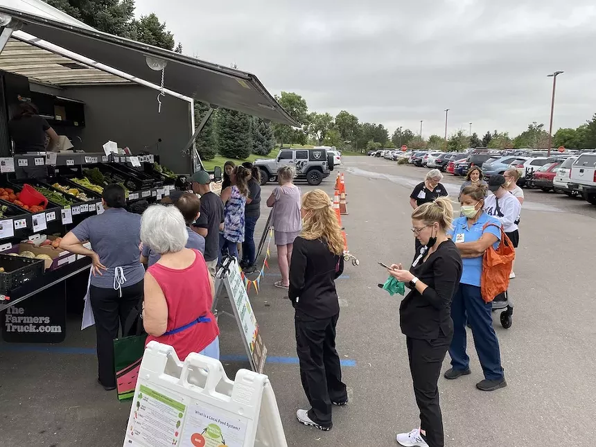 people line up outside to pick up produce