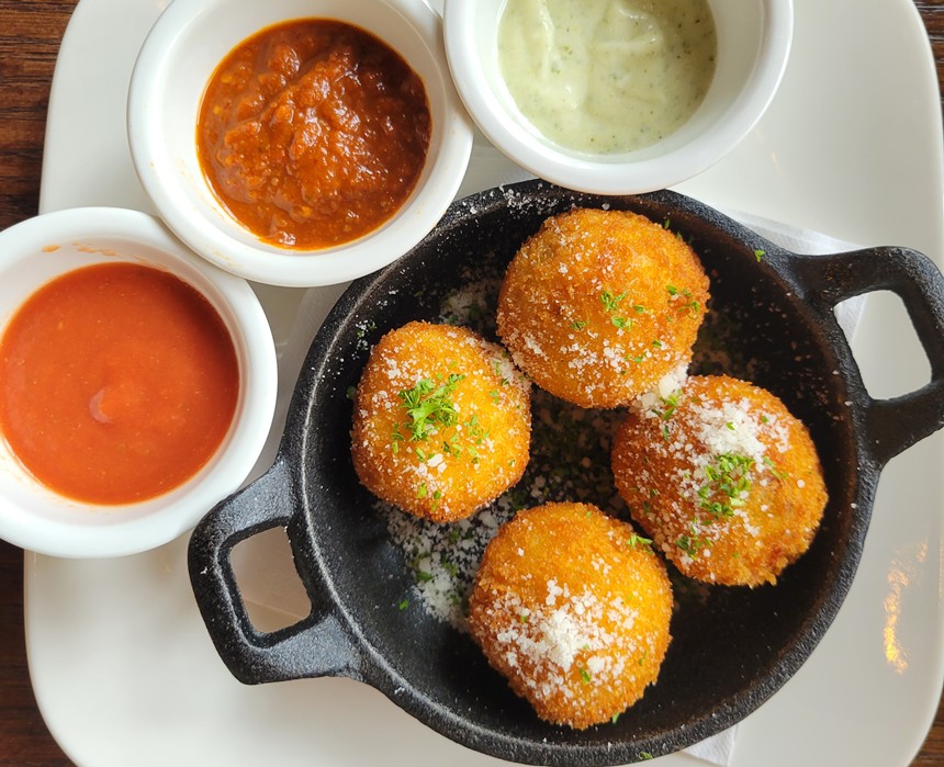 white plate with three sauces and arancini