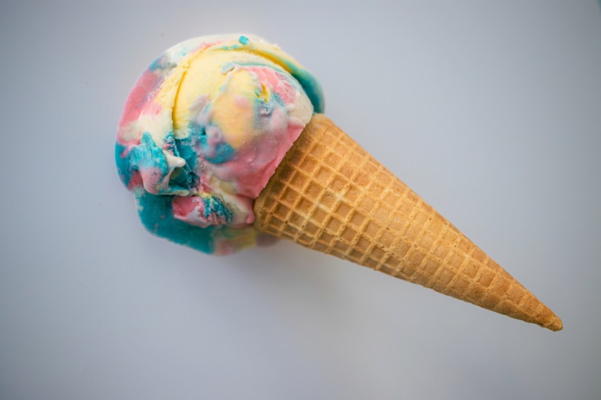 an scoop of rainbow-hued ice cream on a sugar cone