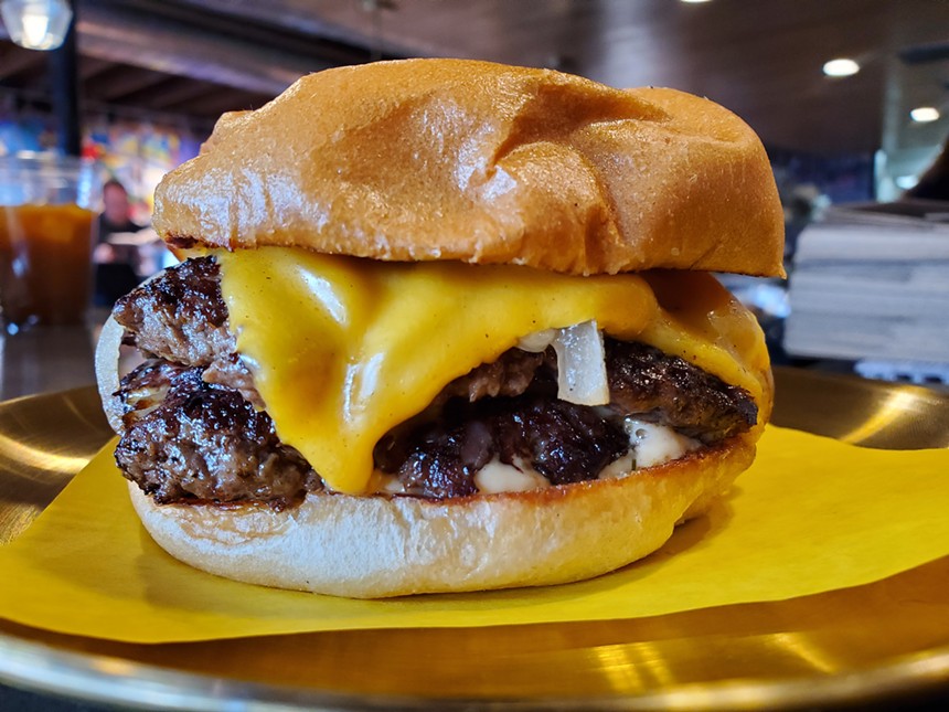 a double cheese burger on yellow paper