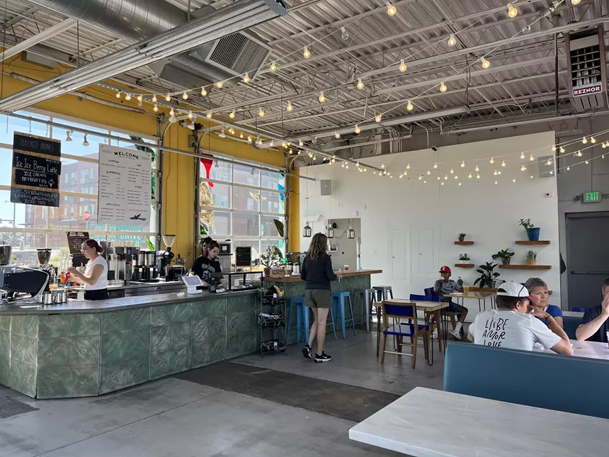 a coffee shop counter with string lights hanging from the ceiling