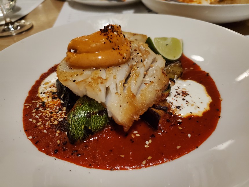 a piece of fish on top of a red sauce