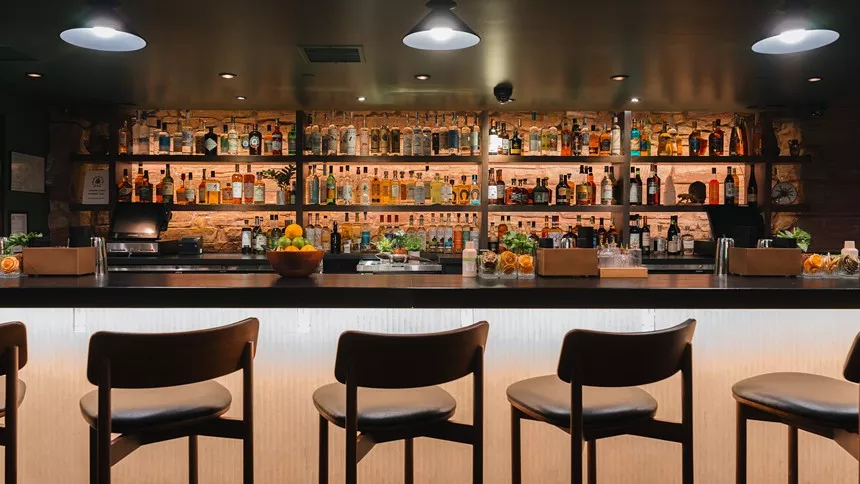 three chairs lined up in front of a bar