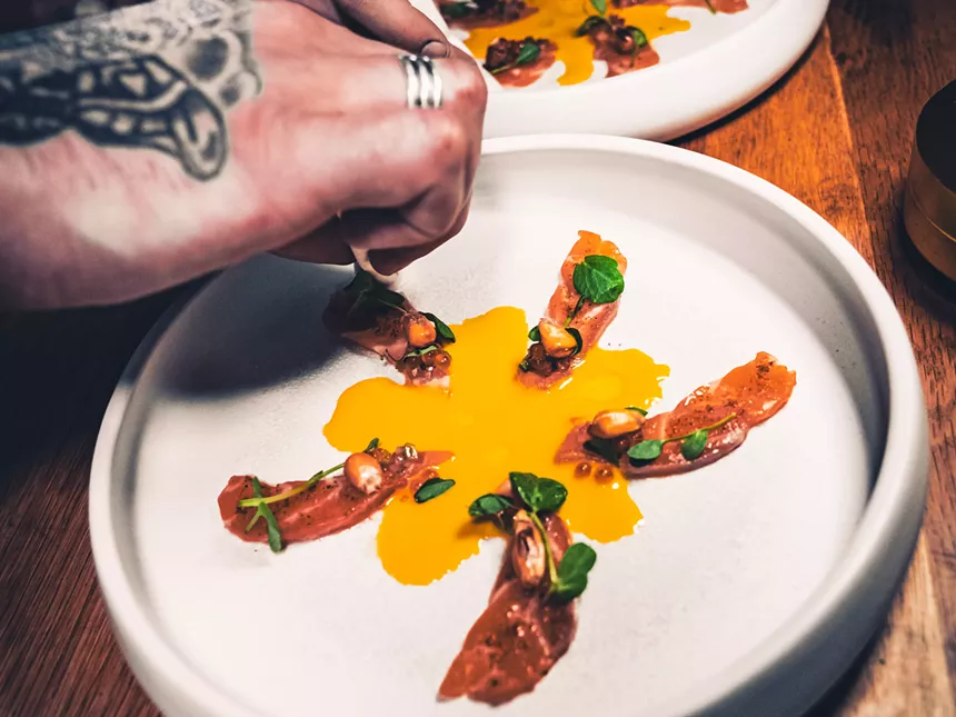 slices on salmon on a plate with orange sauce