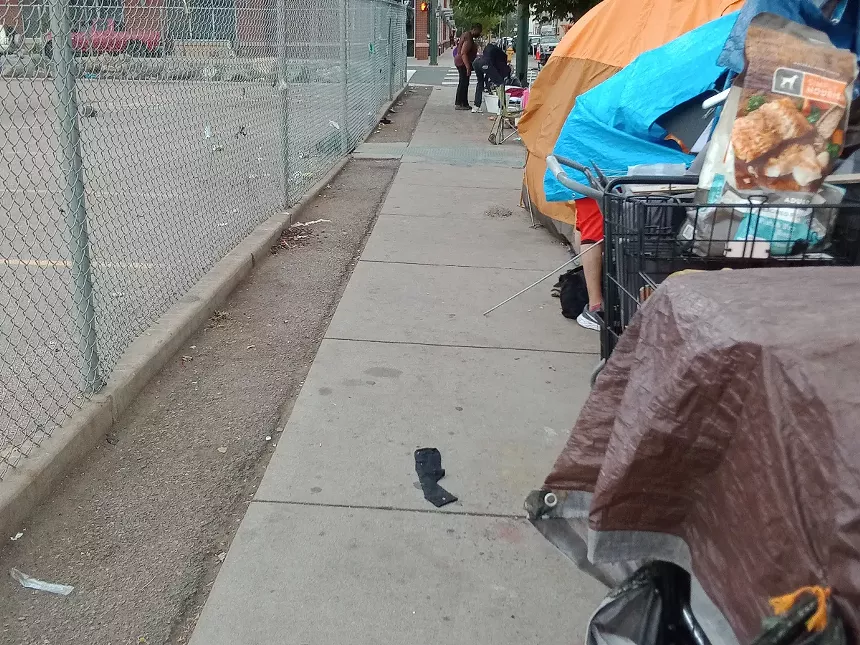 Tents are set up on the sidewalk along 22nd and Stout Street in Downtown Denver.