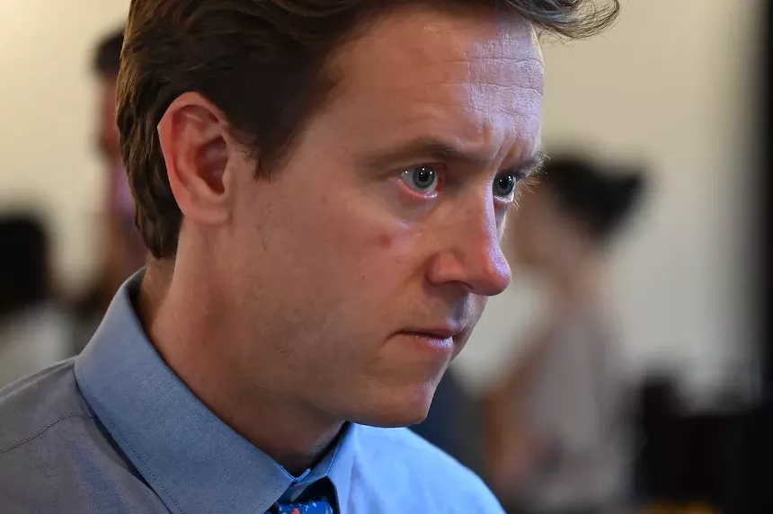 Denver Mayor Mike Johnston focuses on what a resident has to say during a town hall in July.