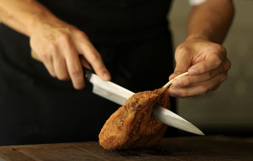 hand holding knife cutting meat