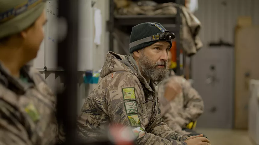 man in camouflage with a headlamp on