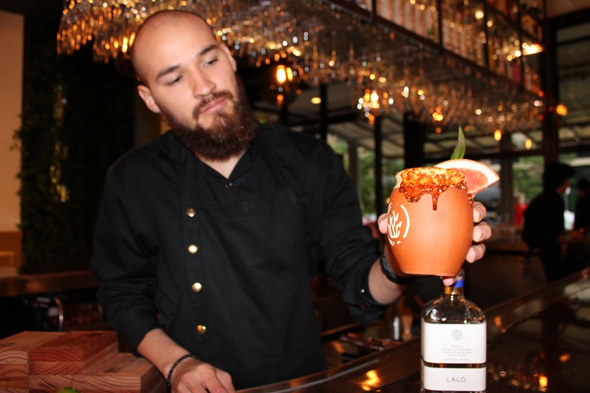 man with beard holding a cocktail