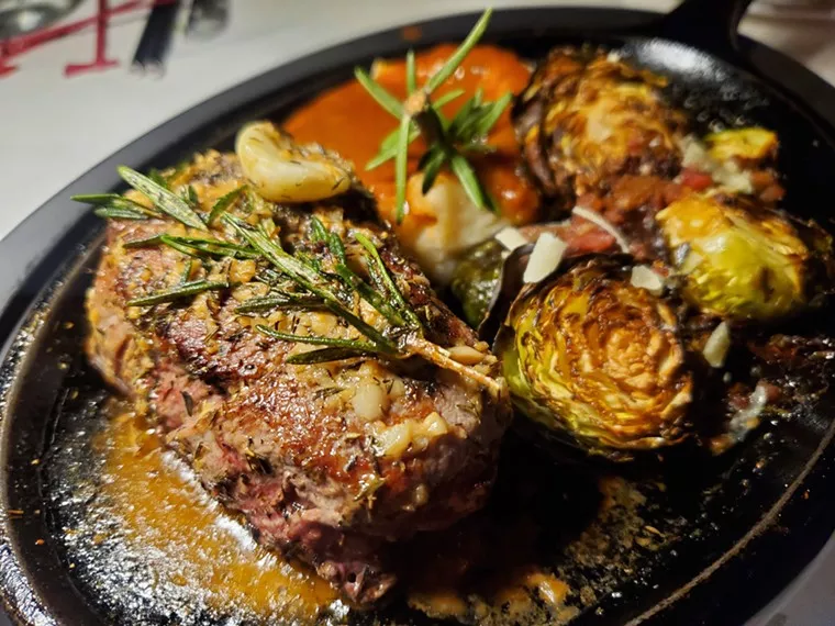 steak on a cast iron plate with Brussels sprouts