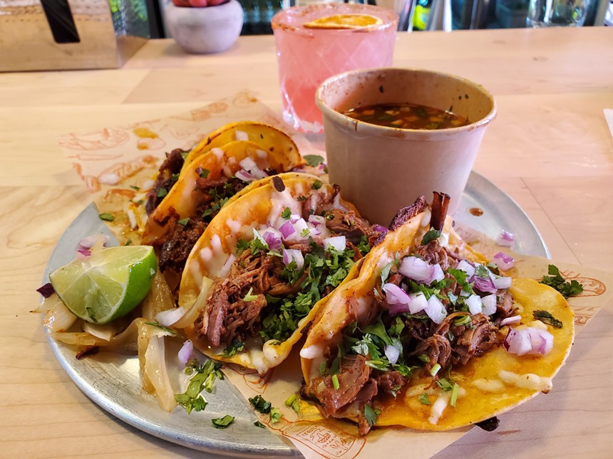 three tacos on a place with a cup of broth