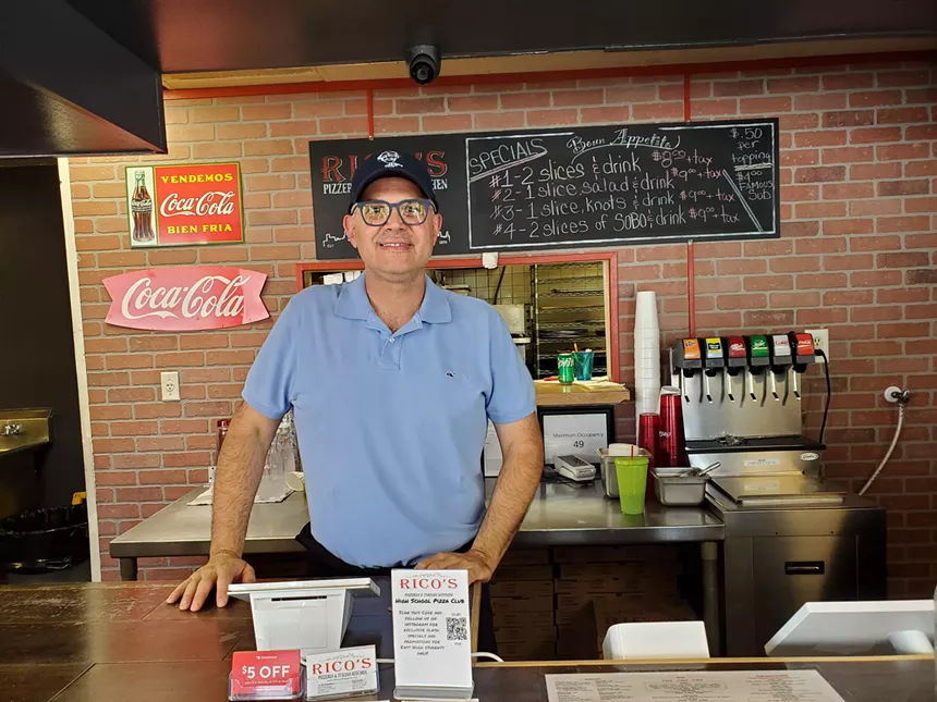 a man standing behind a counter inside a restaurant