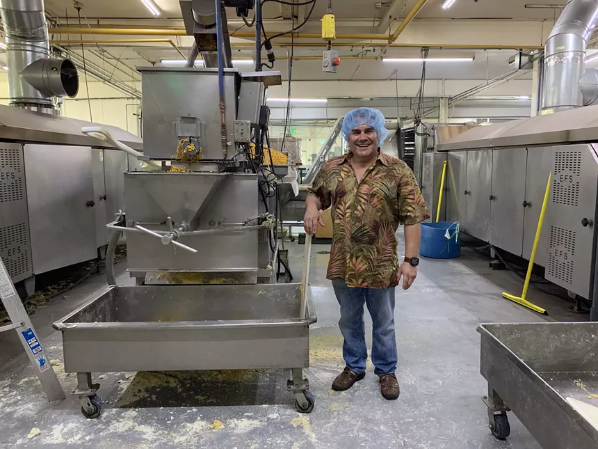 a man in a hairnet next to a machine