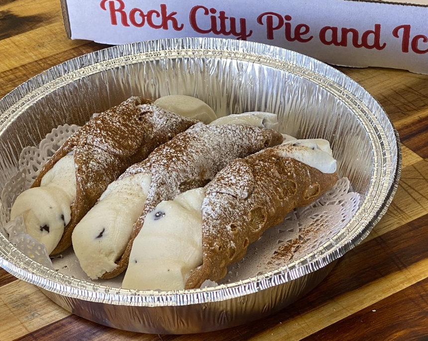 Cannoli desserts lined up on a tray.