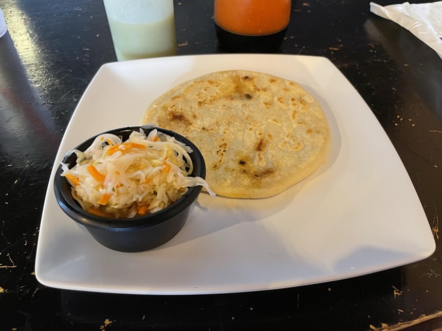 pupusa on a plate with a side of slaw