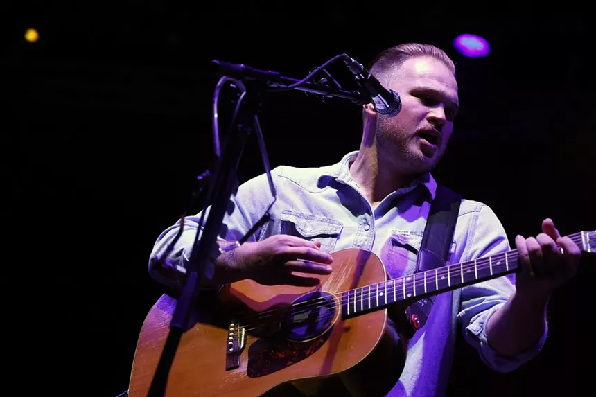 a man playing an acoustic guitar