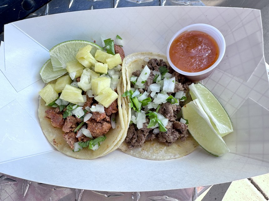 tacos with slices of lime and a cup of salsa