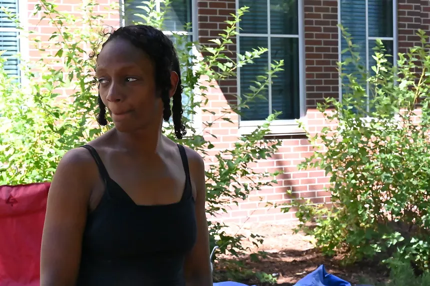 A homeless resident looks back at the spot where she had been staying in an encampment.