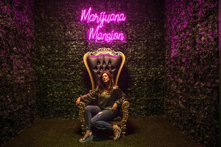 A woman sits on the throne inside Denver's Marijuana Mansion