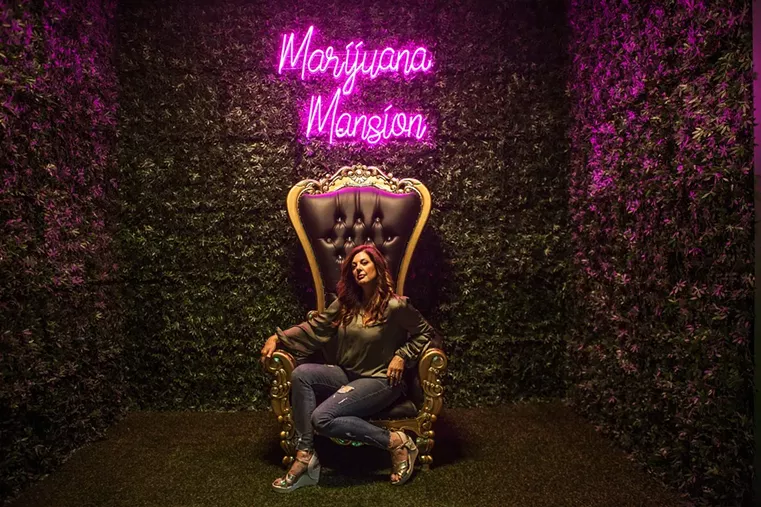 A woman sits on the throne inside Denver's Marijuana Mansion