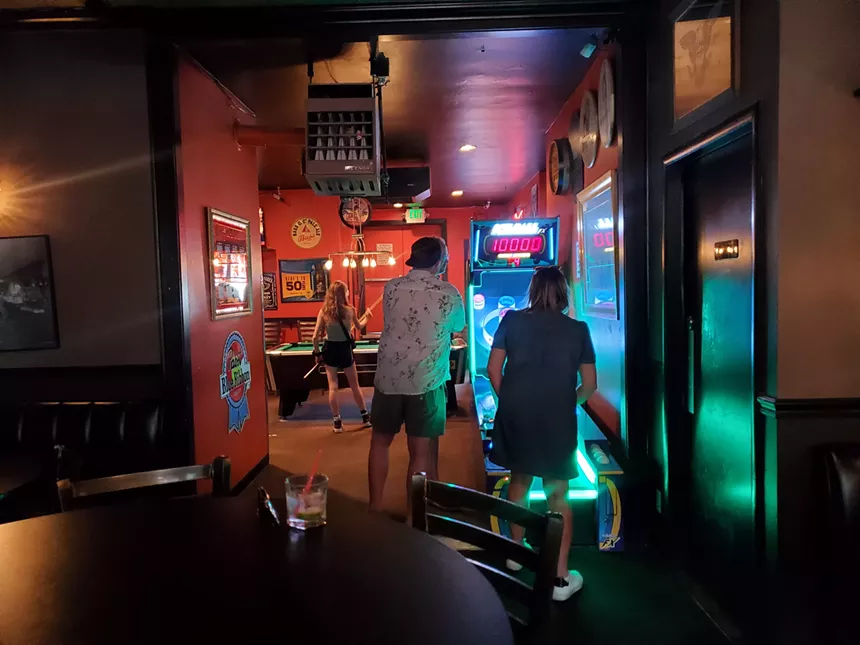 people playing skeeball in a bar