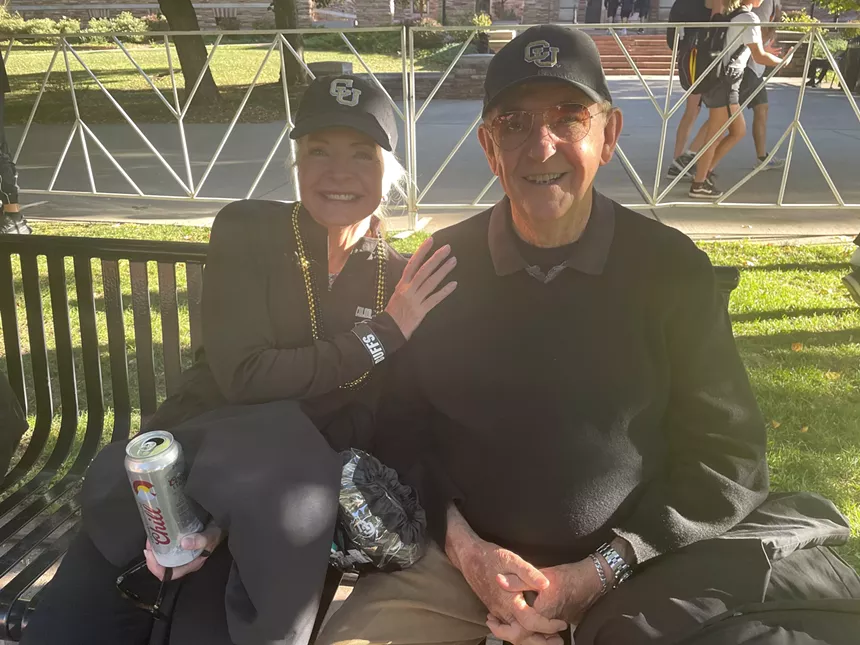 An elderly couple smiles at the camera.