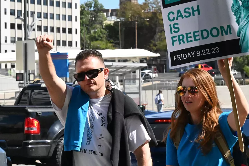 Nick Pacheco walks with protesters supporting the Denver Basic Income Project.