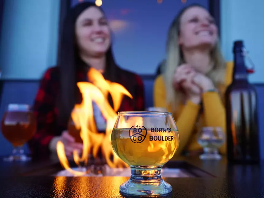 a glass of cider in front of a fire