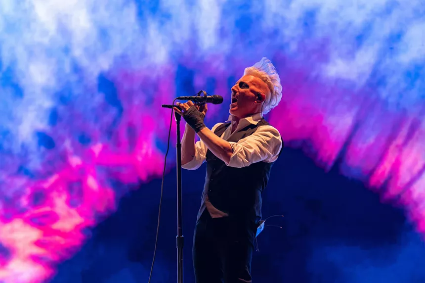 blonde man sings into microphone