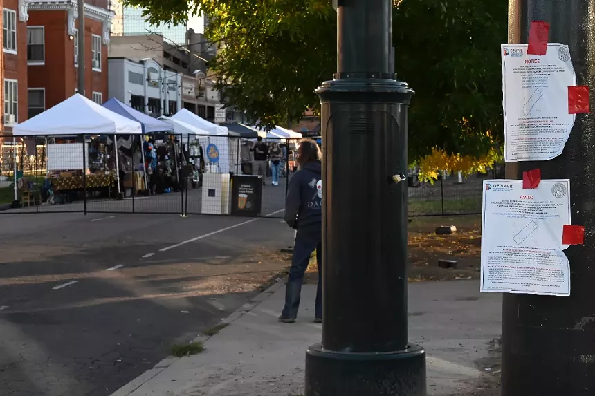A homeless man stands outside of the Woods Boss 2023 block party.