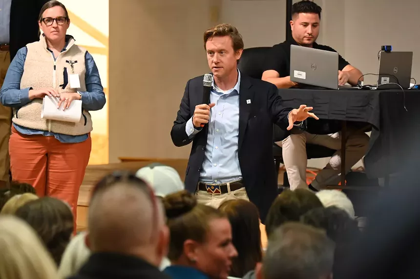 Mayor Mike Johnston speaks to a crowd at the Evans School.